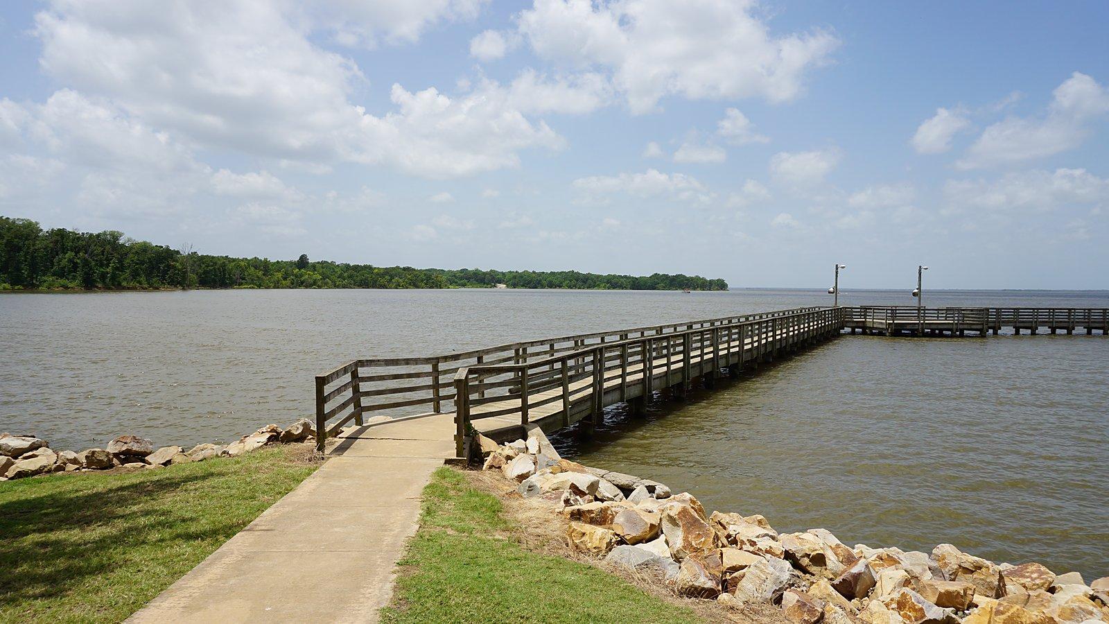 Fishing pier reaching into Cooper Lake under a big Texas sky